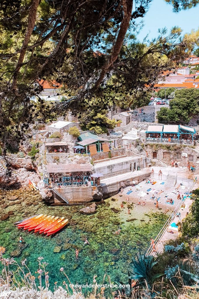 View of Dubrovnik's West Harbour with kayaks and swimmers in clear turquoise water during a family trip with kids