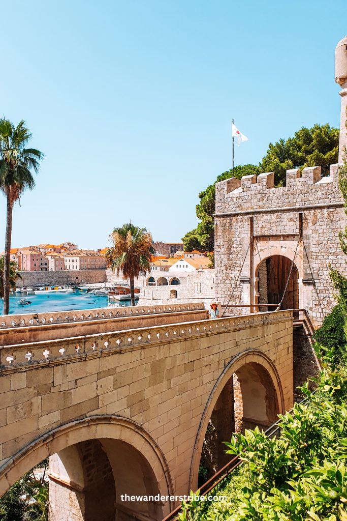 Stone bridge leading to Ploče Gate in Dubrovnik Old Town with views of the marina and city walls, visited on a family holiday