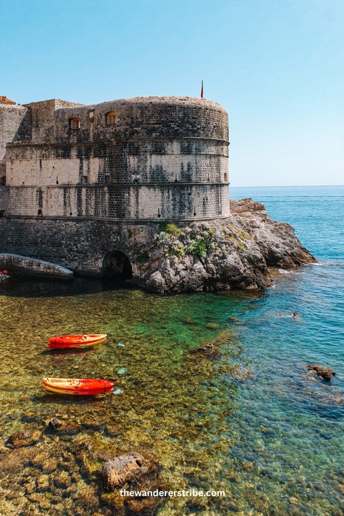 Colourful kayaks floating on the clear Adriatic Sea near Dubrovnik city walls, a popular activity for families with kids